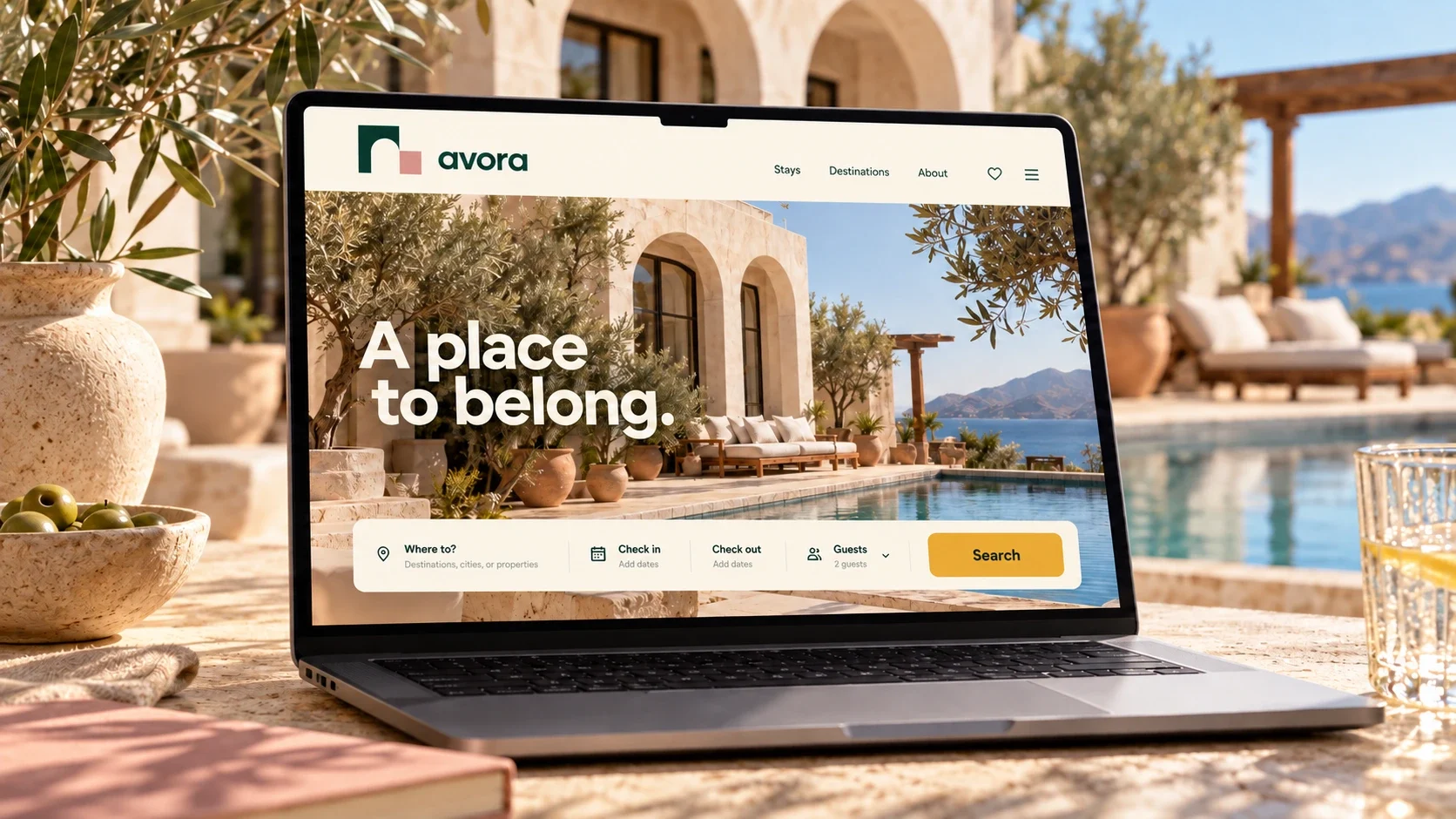 Avora accommodation website shown on a laptop in a courtyard.